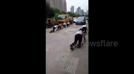 Hair salon workers challenge themselves by crawling on street