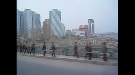 North Korea. DPRK. Pyongyang III. Uniformed workers crossing bridge. 2015