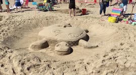 Baby Turtle on top of Large Turtle Sand Sculpture for 39th Annual Contest