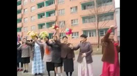 North Korea. DPRK. Pyongyang. Marathon 7. Women with flowers cheering and greeting. 2015