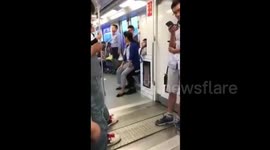 That's one way to get a seat! Elderly woman sits on man's lap on train