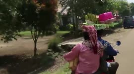 Riding a motorcycle with dowry on the head