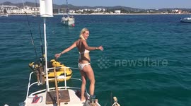 Lady jumping of a sailing boat