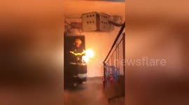 Brave fireman carries flaming gas cylinder out of building