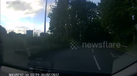 Pedestrian walks in middle of the road in front of car.