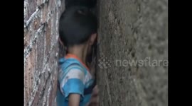 Firefighters free Chinese boy wedged tight between walls