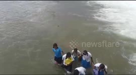 Schoolgirls risk lives to wade through floods to sit exams