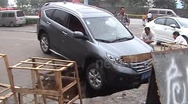 SUV gets stuck in sink hole
