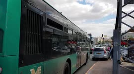 A bus leaving the bus station in a busy street