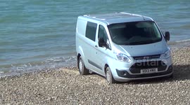 A van is completely submerged by the tide after being parked on a beach by a dosy driver