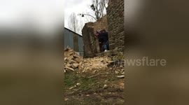 Slow-motion of wall demolition at 125 year old building in France