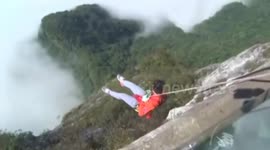 Cleaners abseil to pick up rubbish from cliff under glass bridge