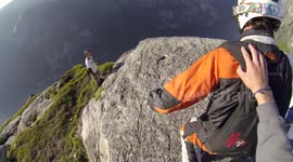 Sheer madness! Daredevils perform headfirst base jump down cliff face
