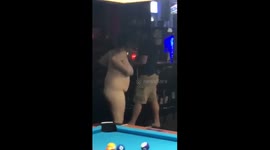 Naked woman chasing man around pool table