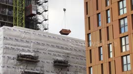 Skips spins dangerously in  the wind on crane and has to be lowered