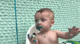 Messy baby can’t fit cake in mouth