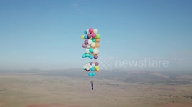 The moment a thrill-seeker floated from 100 helium balloons above South Africa