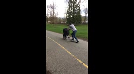 Dad skateboards while pushing stroller