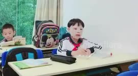 Primary school boy wears facial mask while doing paperwork on tutorial class