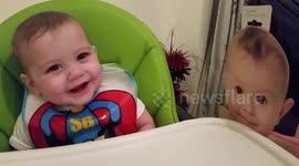 Too cute! UK baby giggles at cardboard cutout of baby