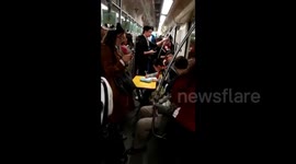Boy does homework on carry-on folding table in subway carriage