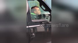 Boy amuses himself against car window while waiting for grandma