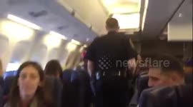 Unruly passenger sings while being escorted from flight