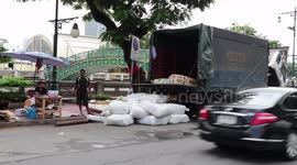 Children playing by jumping from truck onto sacks of rice