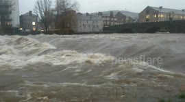 Huge River levels in Kendal Cumbria today after prolonged heavy rain and many areas are experiencing flooding and dangerous driving conditions with schools and roads closed across the county