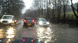 Cars plough through flooded roads in Cumbria