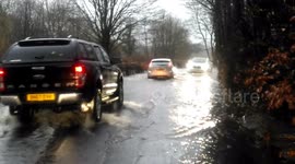 Cars struggle through floodwater in Cumbria