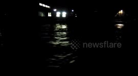 Fast-flowing River Kent in Cumbria floods banks at night