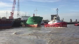 Tugs try to pull ship off jetty on Thames at Grays, Essex