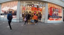 Three Men Carry Big Bags out From The Black Friday sale at Uni Qlo in Oxford Street
