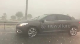 Extreme weather. Hailstorm smashes windows of cars.