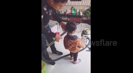 Dad creates cute ponytail on daughter with vacuum cleaner