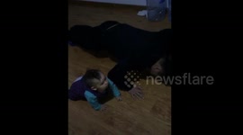 Baby knocks head on floor doing push-ups with dad