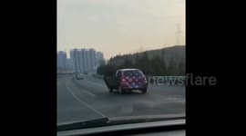 Car drives along motorway with both back doors OPEN