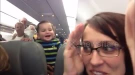 Passenger entertains baby on plane by making him laugh. So cute!