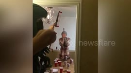 Man fires slingshot at can on friend's head