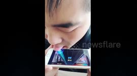 Man plays mobile music game with tongue