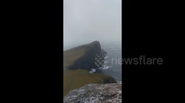 Newsflare Edit - Waterfall flowing backwards in high winds at Neist Point on Isle of Skye during Storm Caroline
