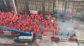 Cheeky builder gestures to female onlookers in nearby offices