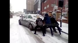 People try to push-start cars on hill as snow hits London