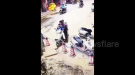 Man drives motorcycle carrying two children and mother into sinkhole