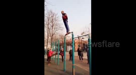 Elderly man fixes feet on horizontal bar to turn around
