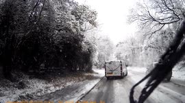 Dashcam footage of vehicles struggling up an icy and snow covered hill