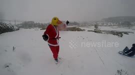A duck dressed as Santa rocking in the snow