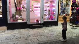 Santa's Little Helper - Cute Puppy Dog Dressed in Santa Clause Costume Plays with Kids while Christmas Shopping
