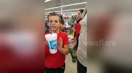 Boy performs floating cup magic trick in supermarket